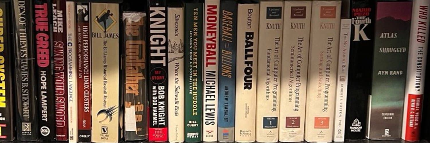 A shelf of Thomas Cocuzza's books, spines facing out